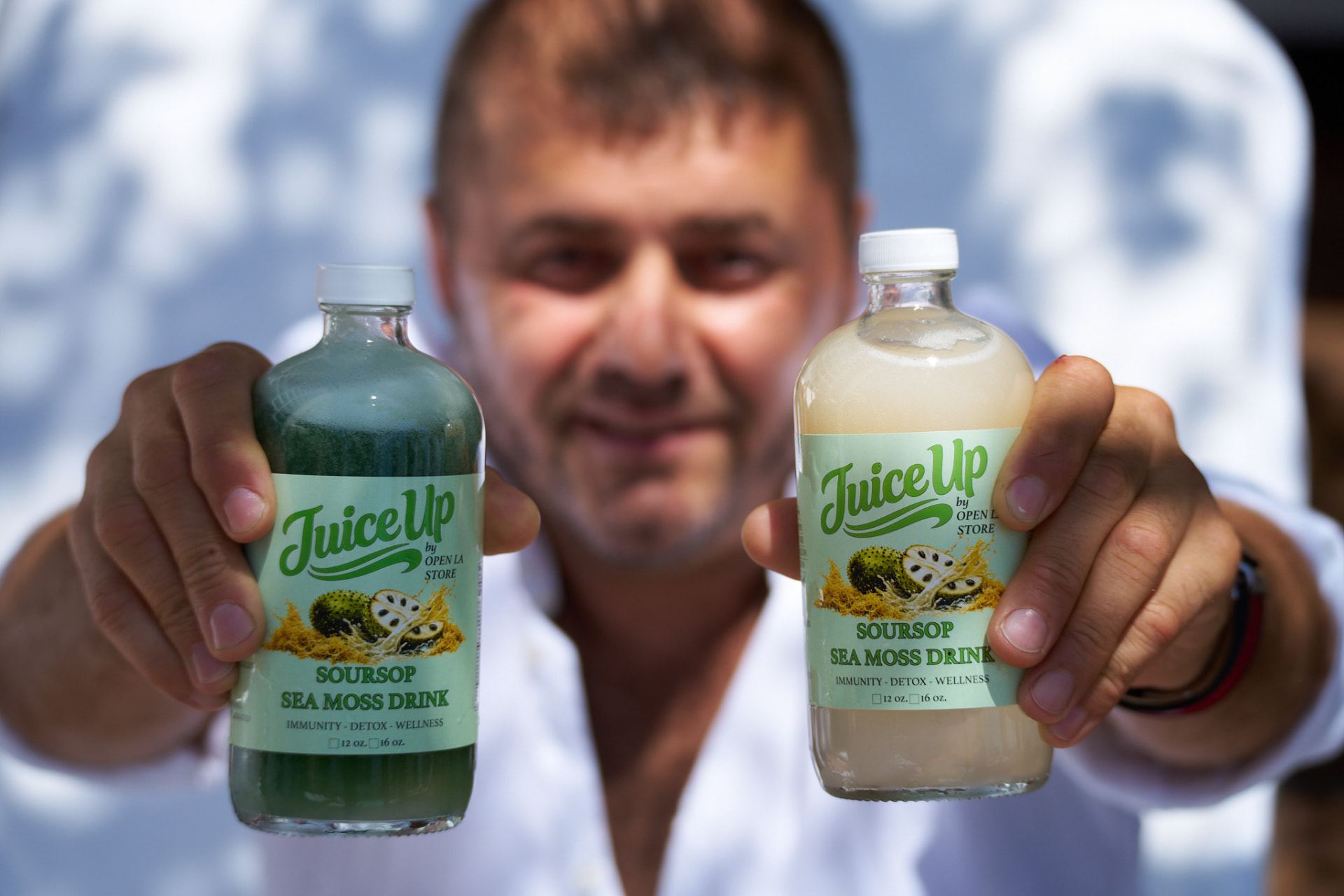 A community member holding two Juice Up bottles
