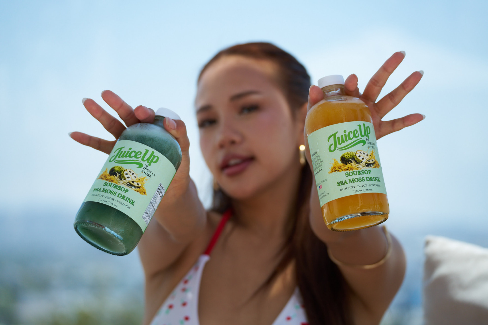 Two Juice Up bottles held up in the California sunshine
